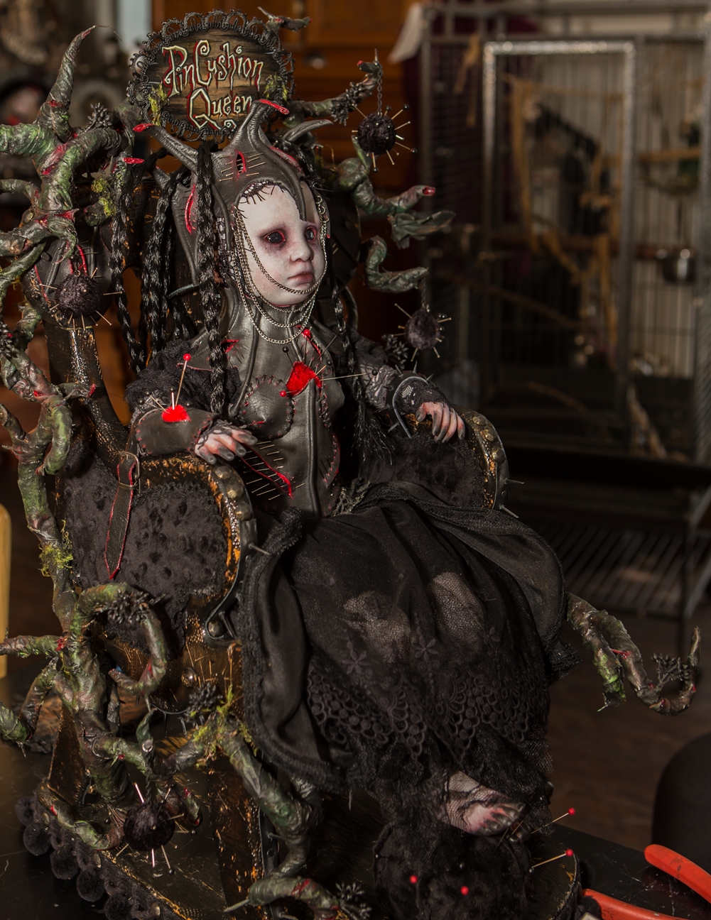 mixed media vinyl doll assemblage dark art goth doll black eyes black leather pins sitting in a throne inspired by Tim Burton