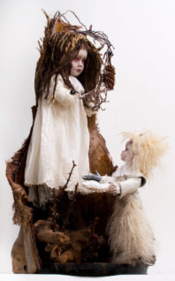 gothic artdoll mixed media damsel with gnarled branches in place of her severed hands. she stands in a piece of wood and is presented a silver hand by a small furred messenger doll