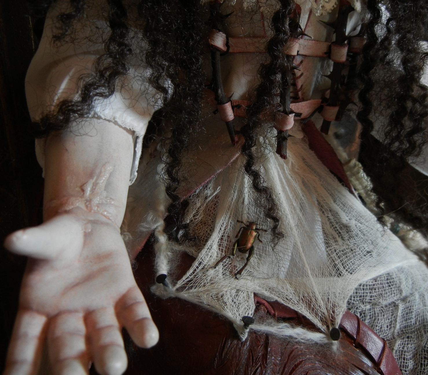 close-up detail of vinyl doll arm with cut wrist suicide scar wearing white gauze