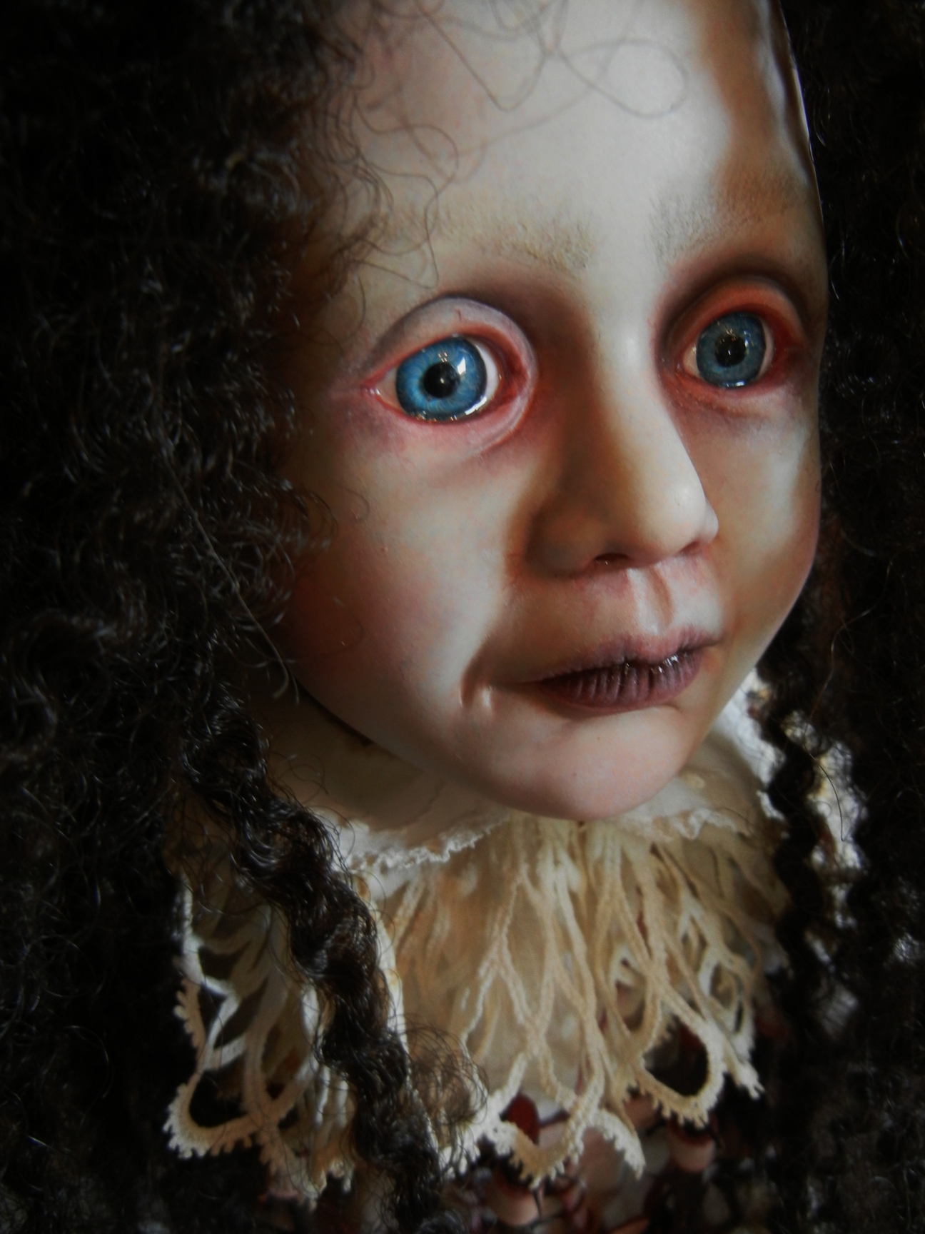 close-up gothic artdoll face repaint pale red-rimmed blue eyes, black ringlets, white lace collar