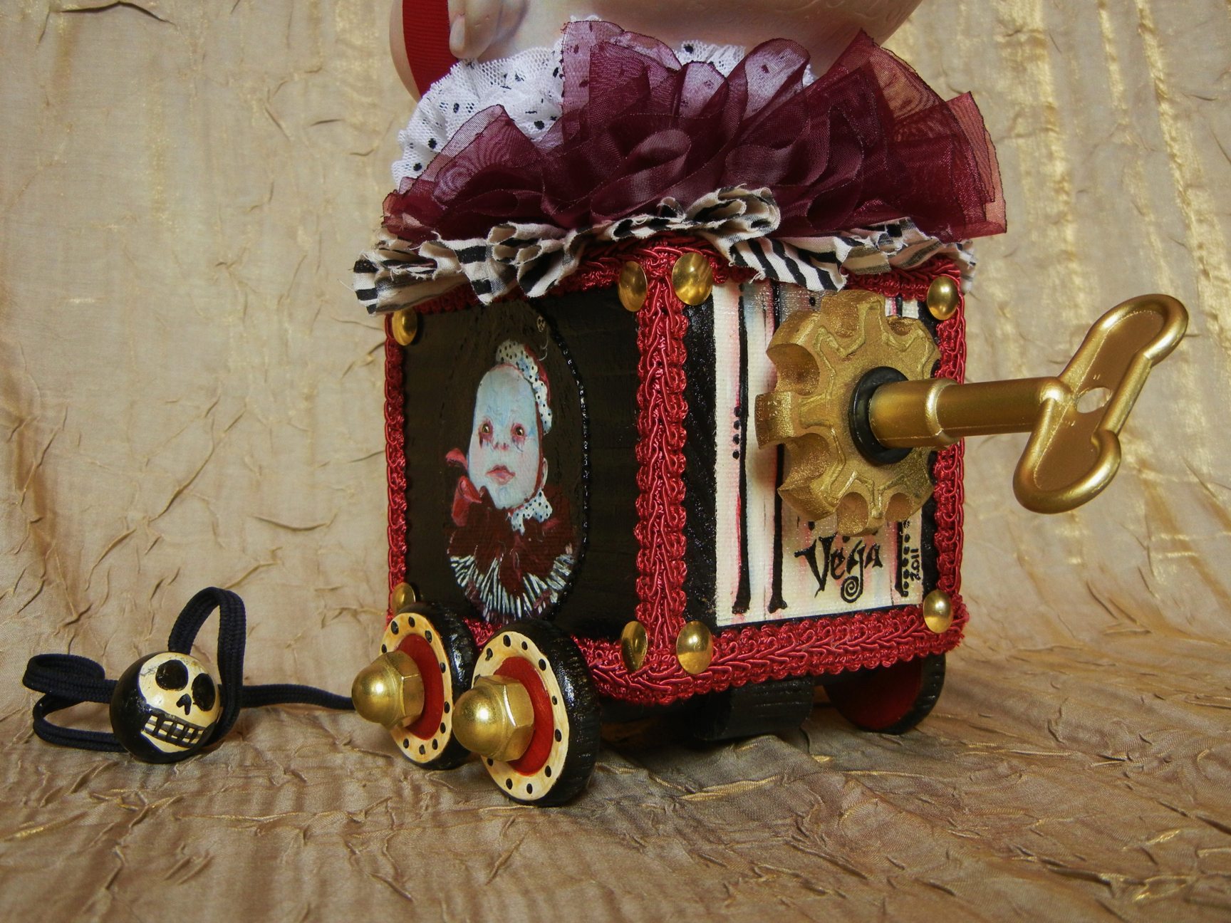 close-up of hand-painted circus pull cart toy red and black with wind-up key music box