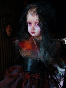 close-up miniature porcelain artdoll gothic repaint with black hair wearing feathers and dark red maroon skirt