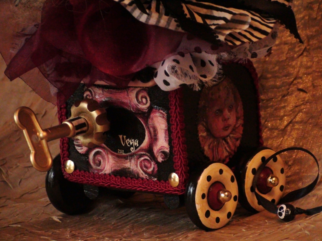 close-up of the wind-up key of a circus-themed gothic hand painted pull cart toy music box