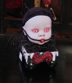 gothic Victorian pin cushion in a ball-gagged porcelain babydoll head, red eyes, black pincushion and ruffled collar hand-painted black and white striped wooden platform
