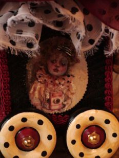 close-up of gothic circus hand painted miniature gothic clown on the side of a pull cart toy music box