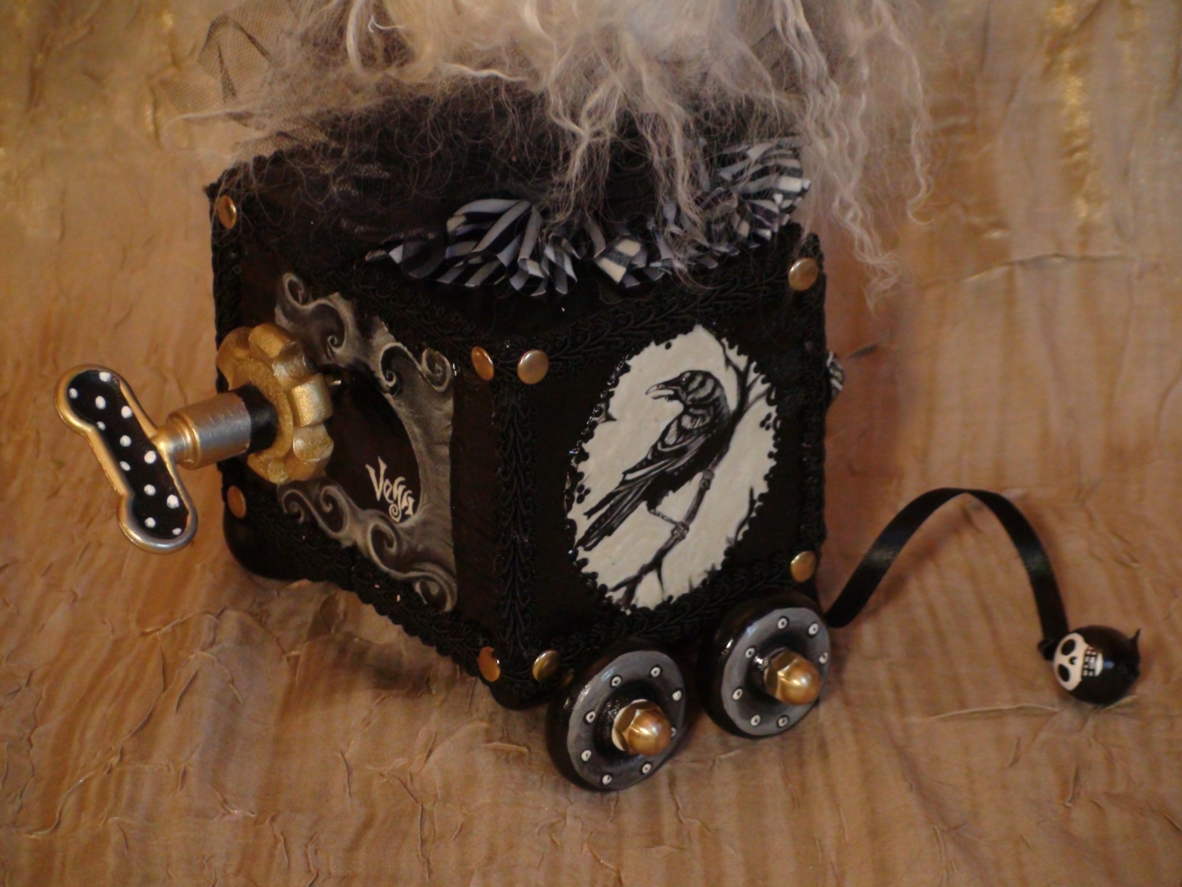 close-up of wind-up pull-cart toy music box raven hand-painted on the side