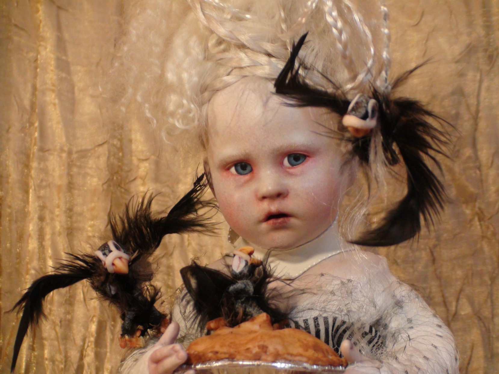 close-up gothic artdoll pale with blond braids and blue eyes black birds flying around her out of pie she holds