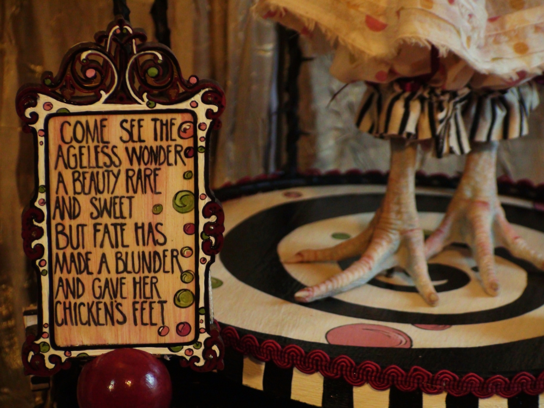 hand painted sideshow circus sign with artdoll with taxidermy chicken feet on spiral platform