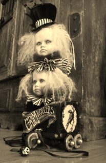 rolling pull-cart toy with a raven painted on the side and two gothic repainted doll heads with wild blond hair inspired by the works of the Brothers Grimm