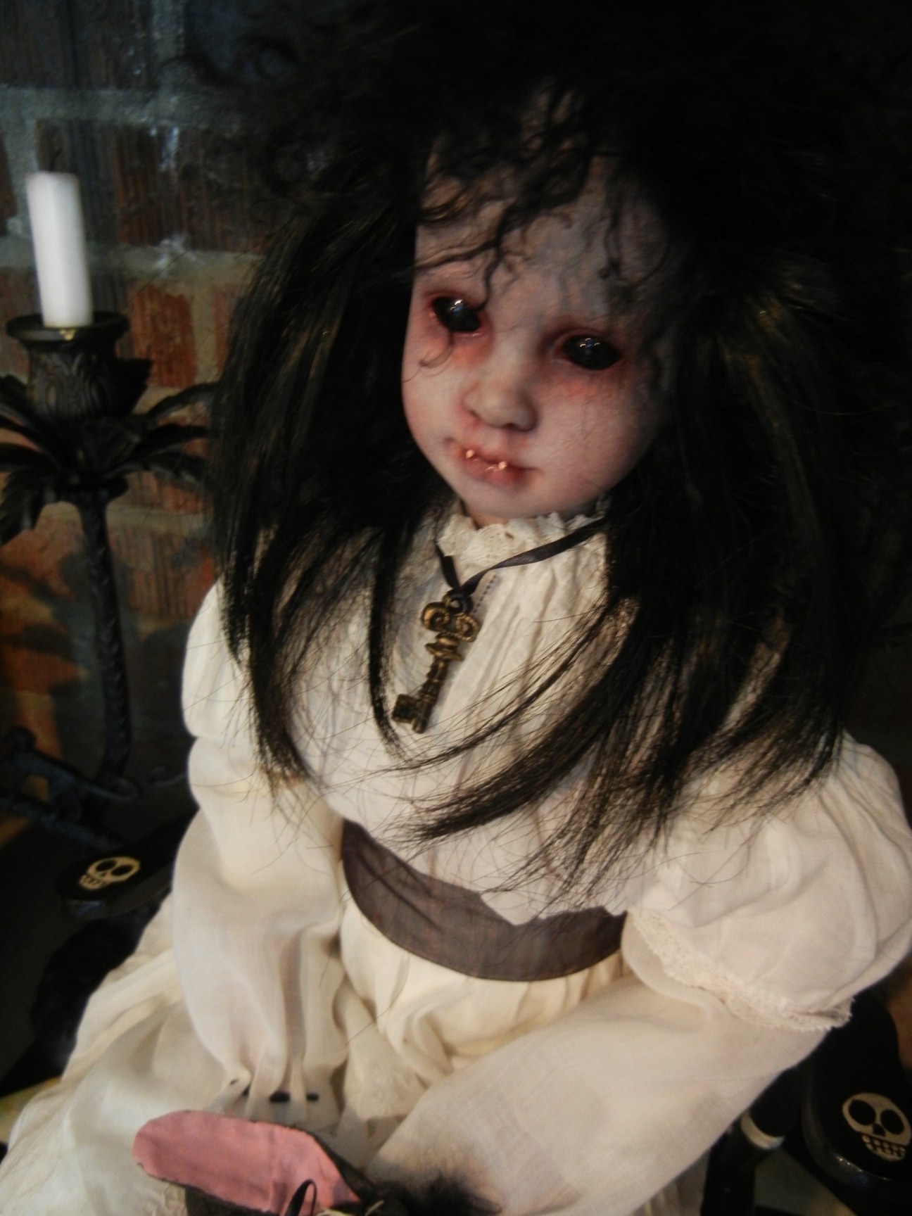seated gothic artdoll pale porcelain repaint with black hair wearing white victorian blouse and bloomers, key necklace