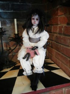 seated gothic artdoll pale porcelain repaint with black hair wearing white victorian blouse and bloomers, black fox feet