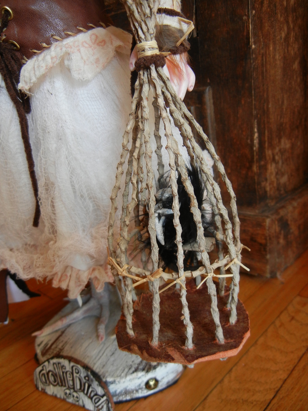 handmade bird cage of sticks with gothic bird inside