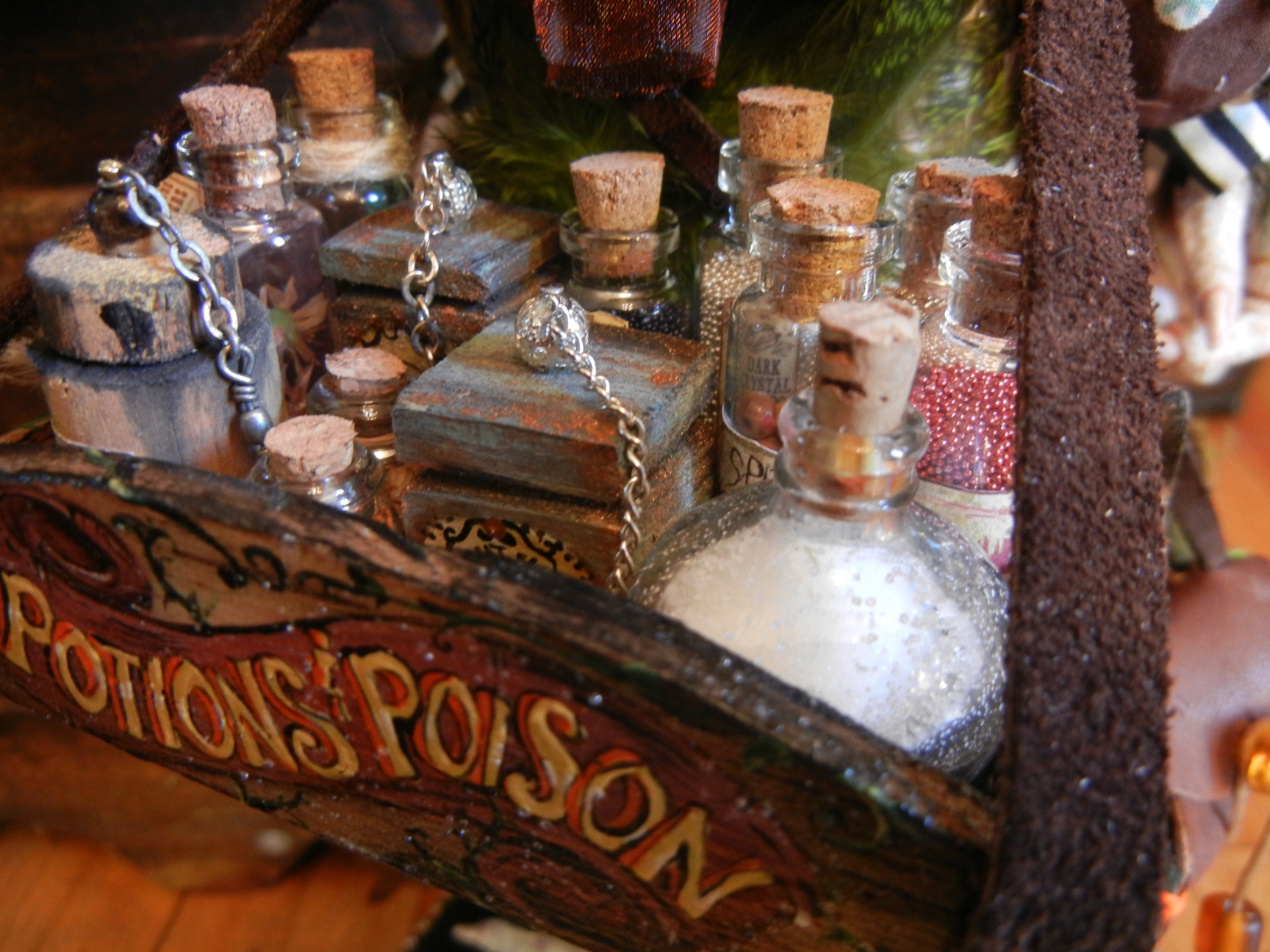 close-up detail wooden tray of corked glass bottles with hand painted lettering reading Potions Poison