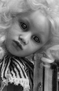 black and white close-up of a gothic artdoll with skulls in her eyes