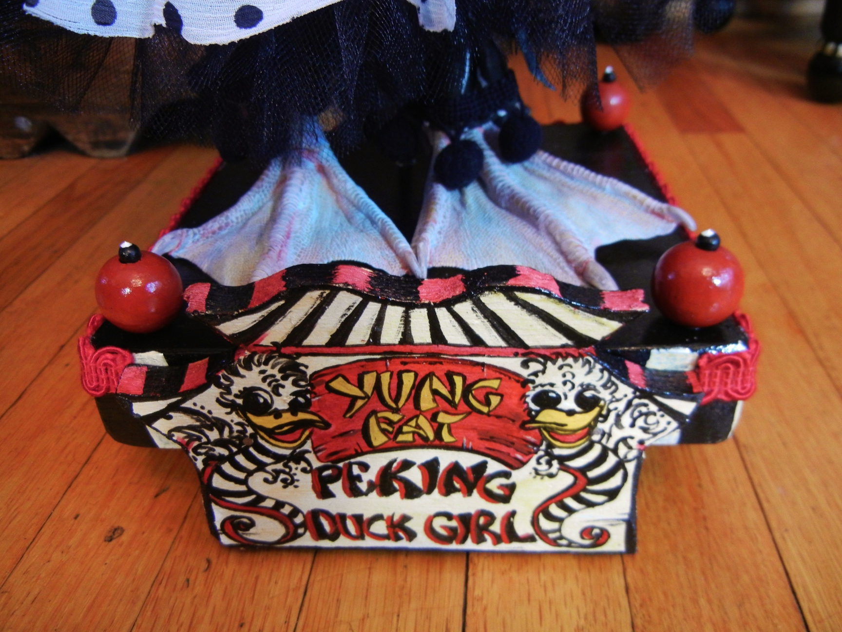 taxidermy webbed duck feet stand on hand-painted wooden platform hand-lettered circus sign reads Yung Fat Peking Duck Girl