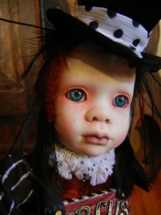 close-up gothic repaint porcelain doll head with blue eyes, feather hair and black tophat