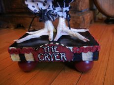 close-up doll's taxidermy birdfeet standing on hand-painted wooden platform black and white stripes