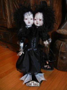 gothic conjoined twins artdoll Asian porcelain doll face repaint, curly black hair, black corset dress, taxidermy webbed bird duck feet holding pet bird in a cage