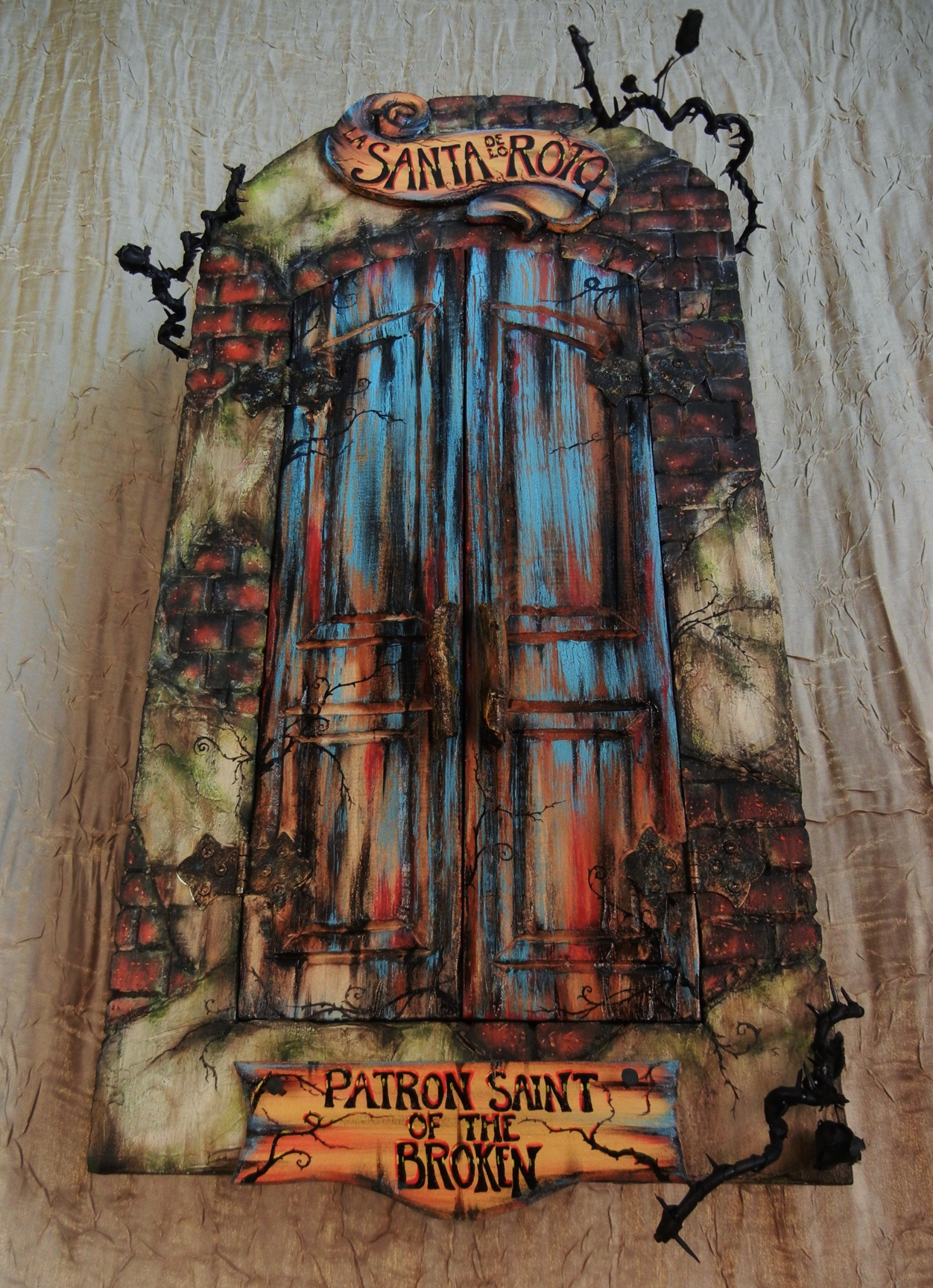 mixed media assemblage art box cabinet with painted doors closed reads Patron Saint of the Broken