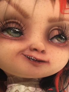close-up of gothic repaint of doll sprite face with freckles and long eyelashes