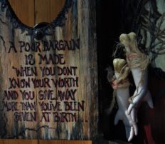 close-up of mixed media shadow box cabinet holding severed maiden's hands with a hand painted poem on the door