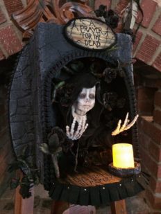 mixed media altarbox and nightlight holding a saintly skeletal figure surrounded by black roses.
