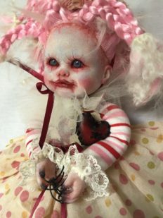close-up face gothic repaint porcelain doll dark circus clown makeup with pink and white braids, striped and polka-dot dress