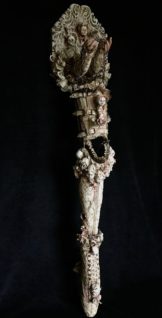 art piece Prosthetic Leg adorned with porcelain doll heads, vintage textiles, lace & mixed media.