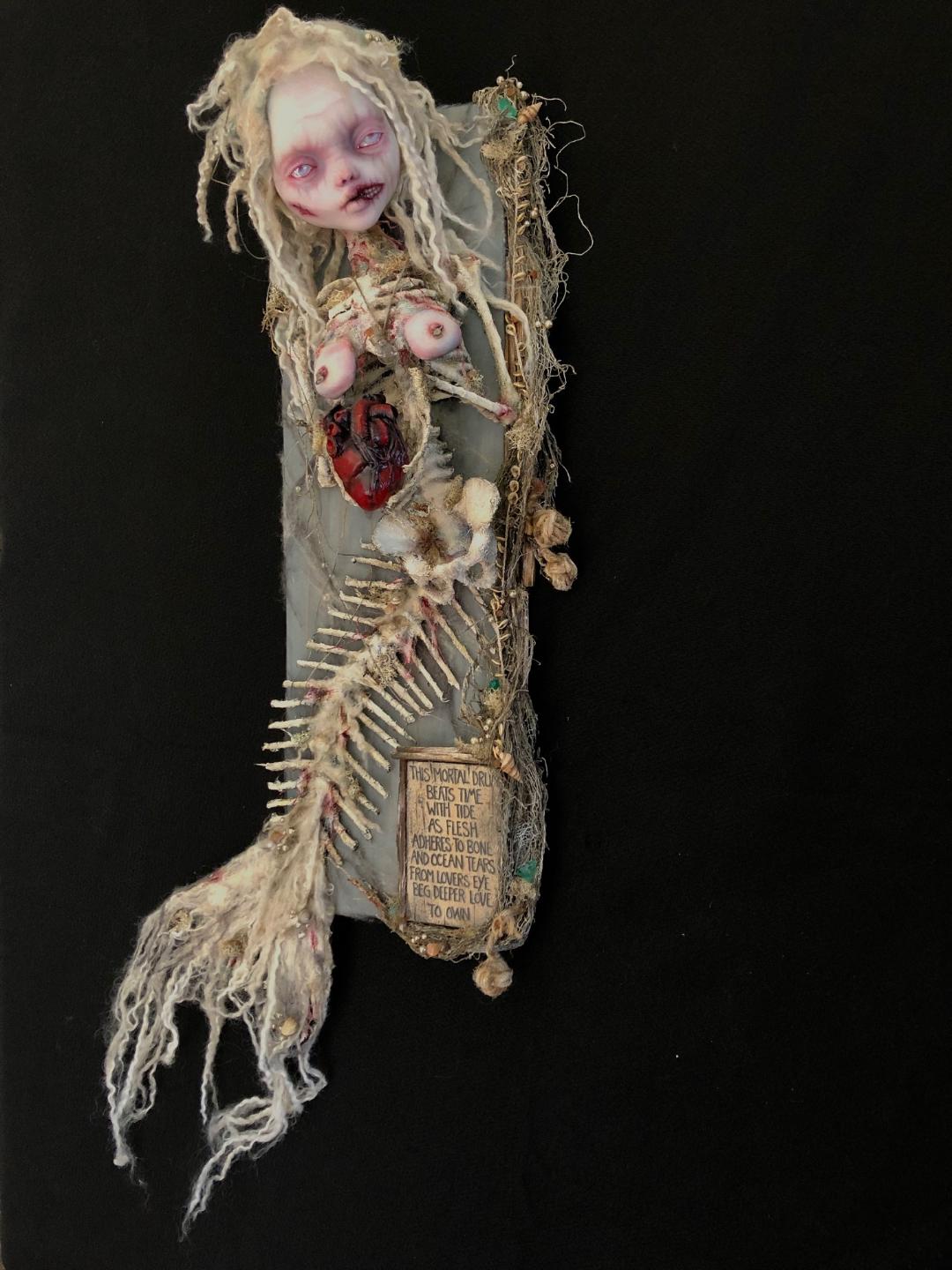 mixed media assemblage of a ghostly skeletal mermaid holding a bleeding heart goth doll repaint