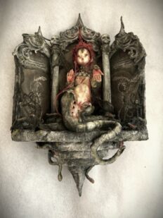 adorned snake goddess doll in altar wall hanging setting