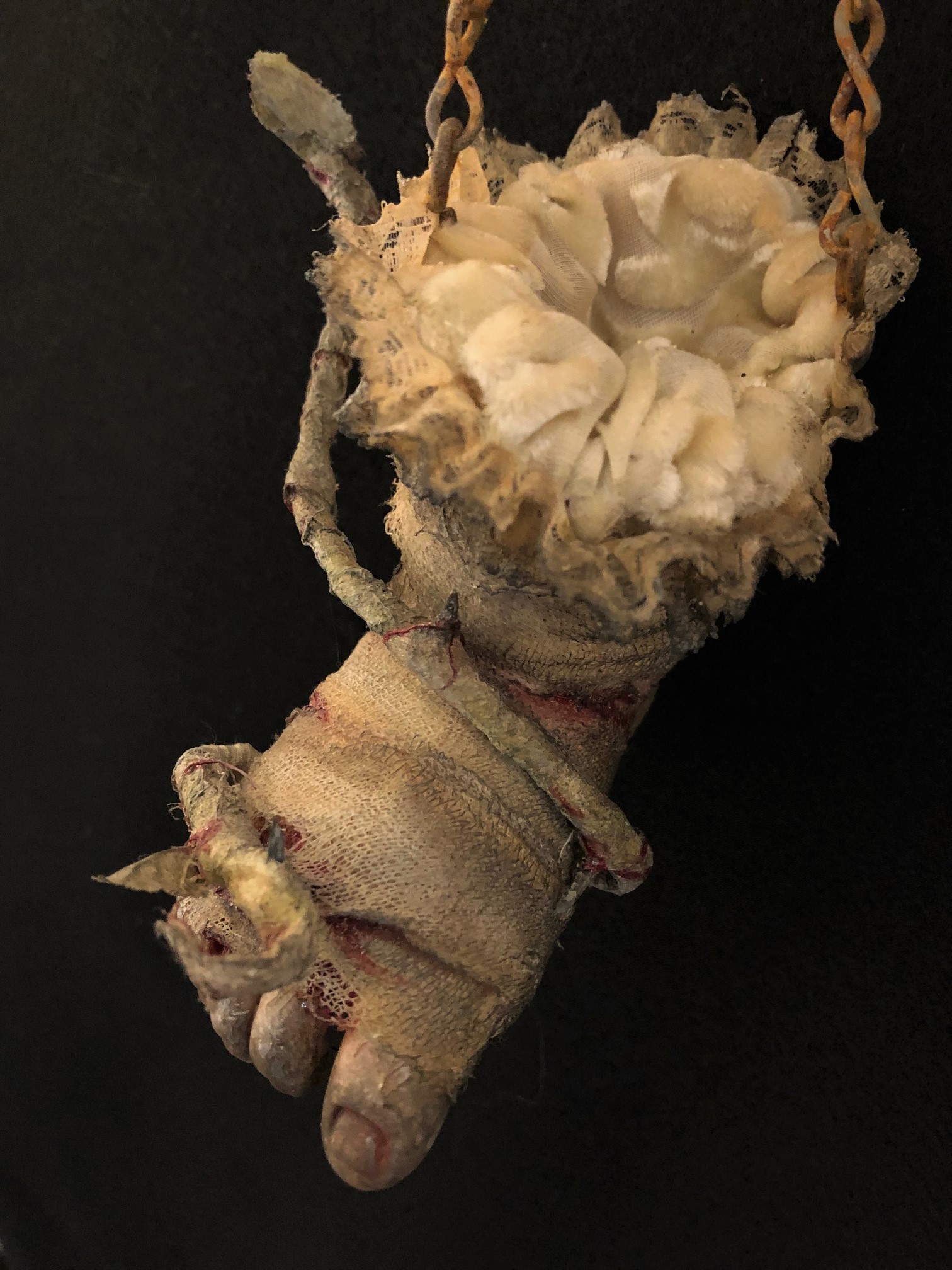 close up of art piece severed baby doll foot bandage wrapped bloody