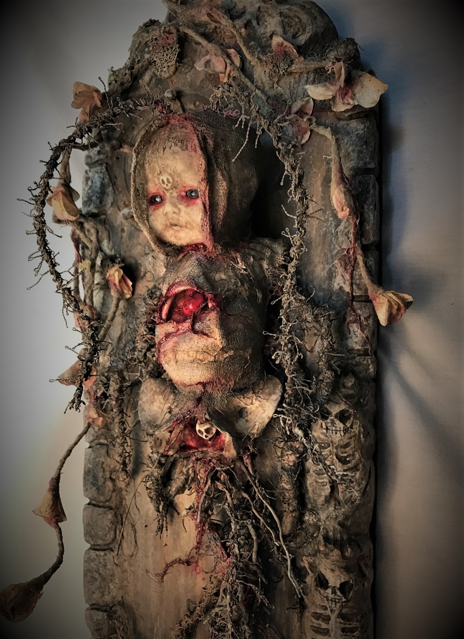 mixed media assemblage ghostly repainted baby doll mounted on wooden board dark art doll split bleeding chest