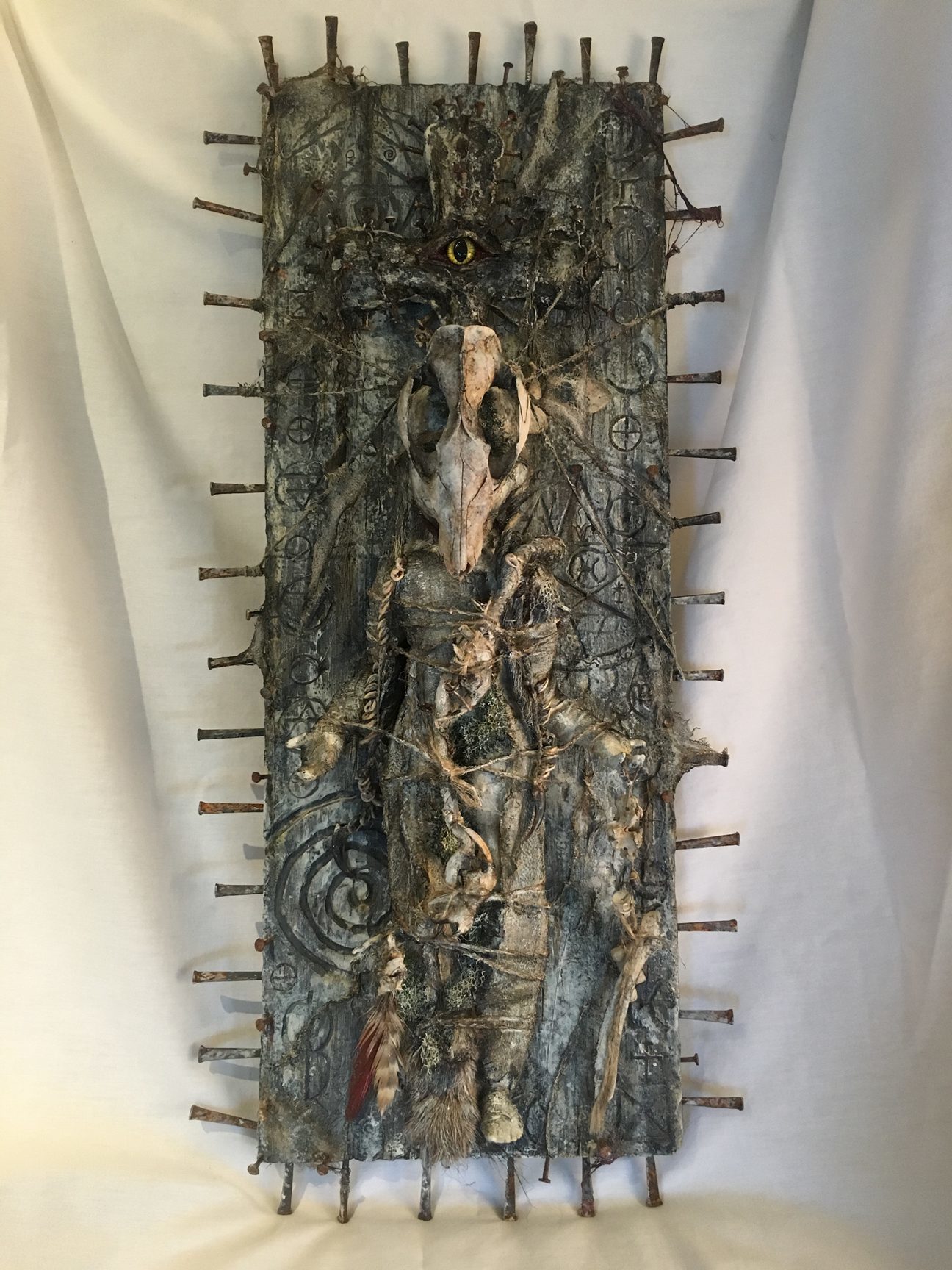 mixed media taxidermy assemblage repainted babydoll decorated with bones mounted to witchy board occult artifact