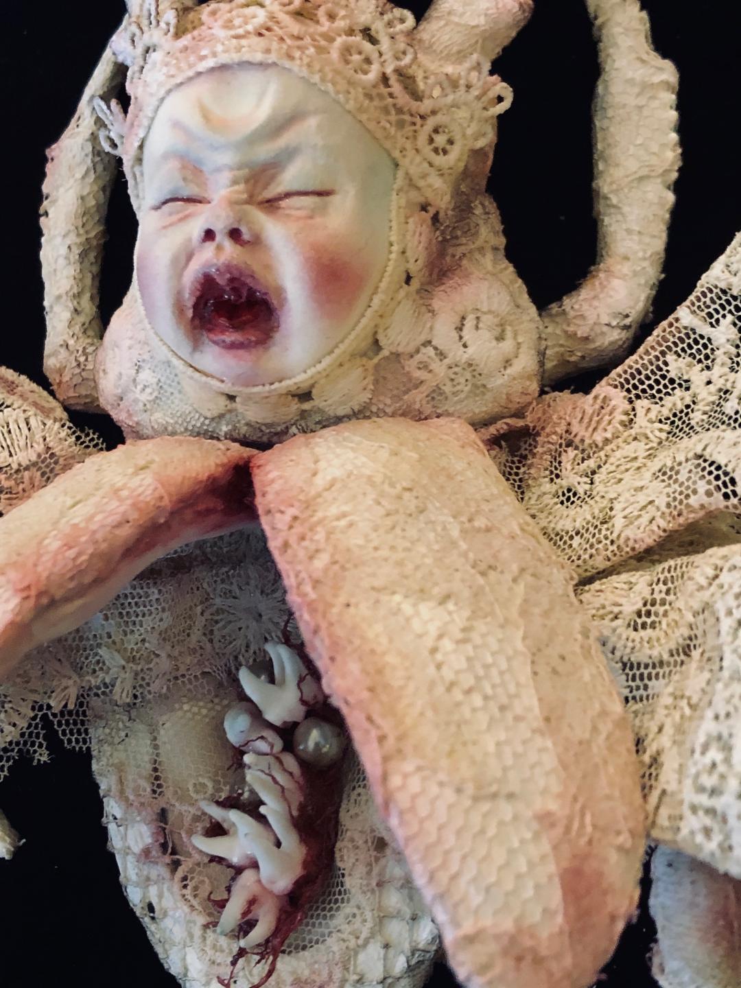 close up mixed media assemblage crying baby paper, teeth and lace sculpted beetle by artist Stefanie Vega