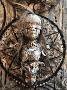 close-up of wall plaque blindfolded doll on pentagram witch markings on wood