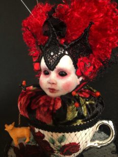 queen of hearts themed velvet pincushion porcelain dollhead sits in a bone china teacup with red roses