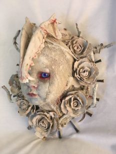 repainted baby doll head bone and white rose headdress red-rimmed blue eyes macabre
