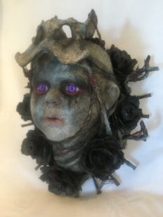 dark repainted baby doll head bone and flower headdress purple eyes