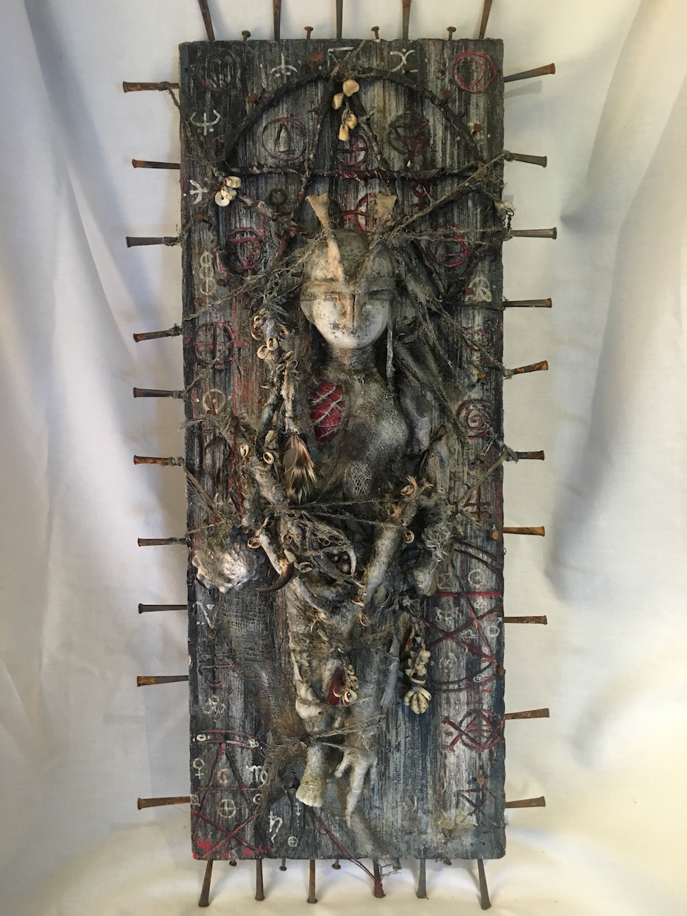 mixed media assemblage plaque bloody mummified babydoll with animal bones and pagan symbols