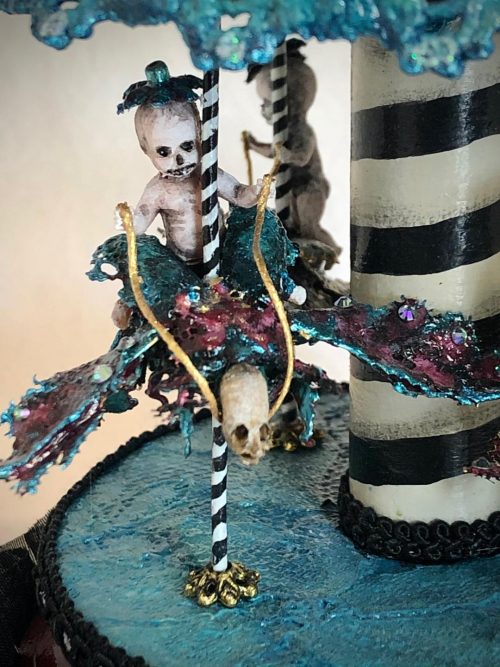 close-up tiny goth skeleton riding a bejeweled blue and purple beetle around a gothic striped carousel music box black, blue, purple and white