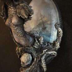 close up mixed media sculpted assemblage of a haunting miniature ship figurehead with skull tentacles