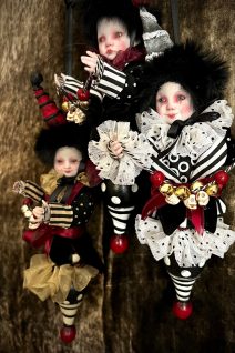 three porcelain and wooden doll christmas ornaments black, white and red