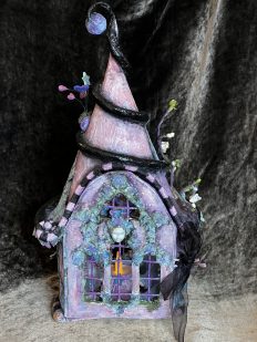 purple miniature fairy house with a face on the front mixed media art