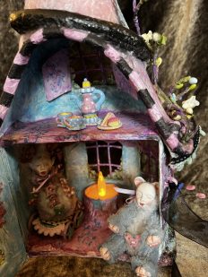 close-up miniature fairy house with furry mouse creatures tea party