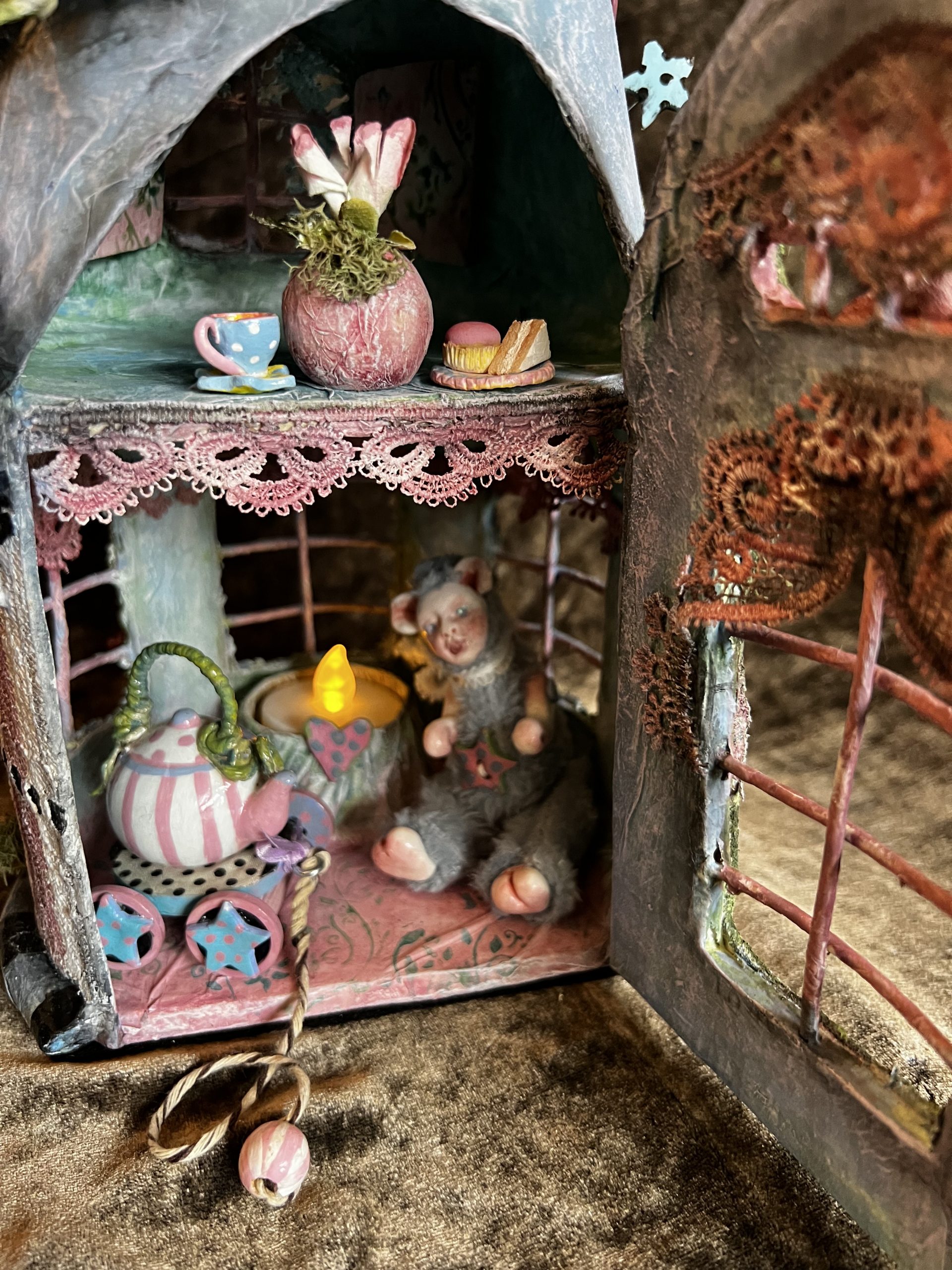 close-up miniature fairy house with furry mouse creature tea party
