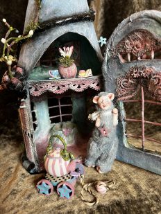 close-up miniature fairy house with furry mouse creature tea party