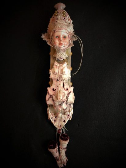 mixed media assemblage deconstructed art doll with violin torso and severed head and feet mounted on wooden board hand painted