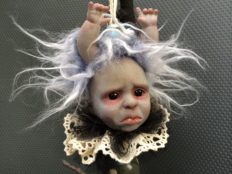 hand painted vinyl doll head with light purple and white fur hair and doll hands coming out of it's head white lace collar baby blue details gothic Christmas tree holiday ornament