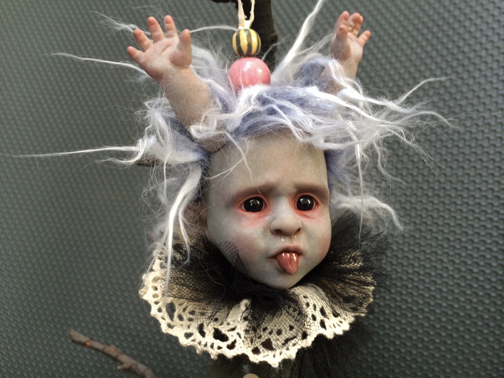 hand painted vinyl doll head with light purple and white fur hair and doll hands coming out of it's head white lace collar baby pink details gothic Christmas tree holiday ornament