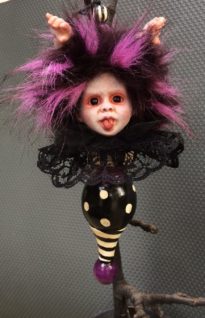 hand painted vinyl doll head with purple and black fur hair and doll hands coming out of it's head black lace collar attached to hand painted finial gothic Christmas tree holiday ornament
